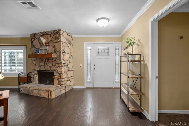 an empty room with wooden floor fireplace and windows