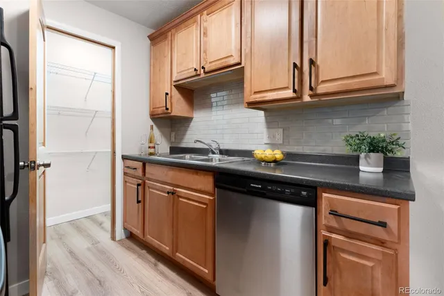 a kitchen with stainless steel appliances granite countertop a stove a sink and a granite counter tops with white cabinets