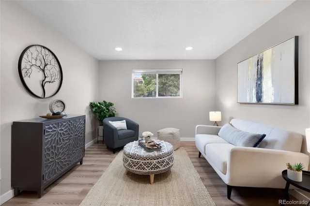 a living room with furniture a clock and a large window