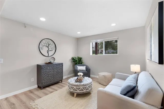 a living room with furniture a clock and a window