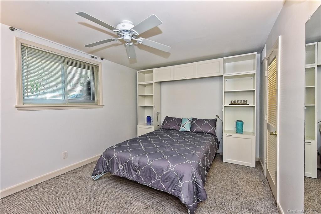 400 Queens Road, Unit D1 Charlotte, NC 28207 - Photo 15 of 23 a bedroom with a bed and a chandelier