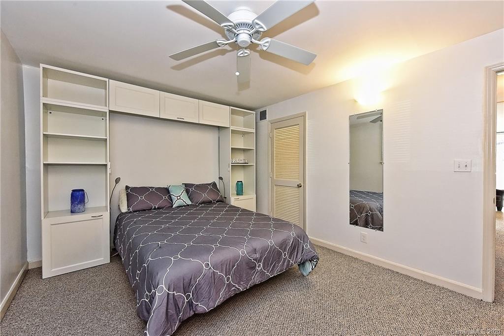 400 Queens Road, Unit D1 Charlotte, NC 28207 - Photo 16 of 23 a bedroom with a bed and a chandelier