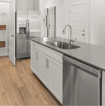 a kitchen with stainless steel appliances granite countertop a sink and a refrigerator