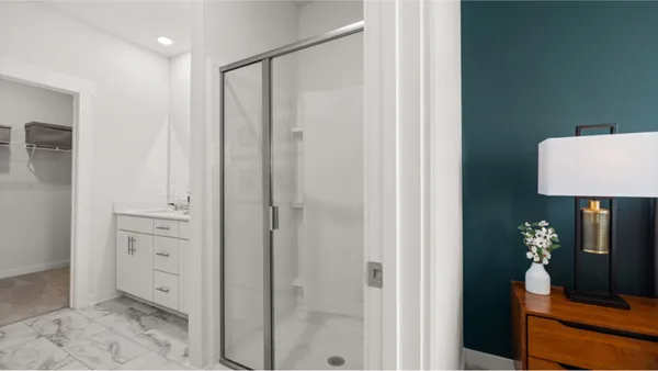 a spacious bathroom with a shower a sink and a mirror