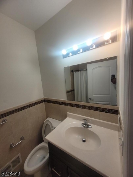 452 Fulton Street, Unit 1 Elizabeth Port, NJ 07206 - Photo 2 of 12 a bathroom with a sink mirror vanity and toilet