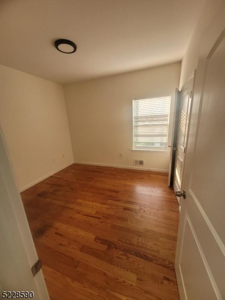 452 Fulton Street, Unit 1 Elizabeth Port, NJ 07206 - Photo 5 of 12 a view of empty room with wooden floor and fan