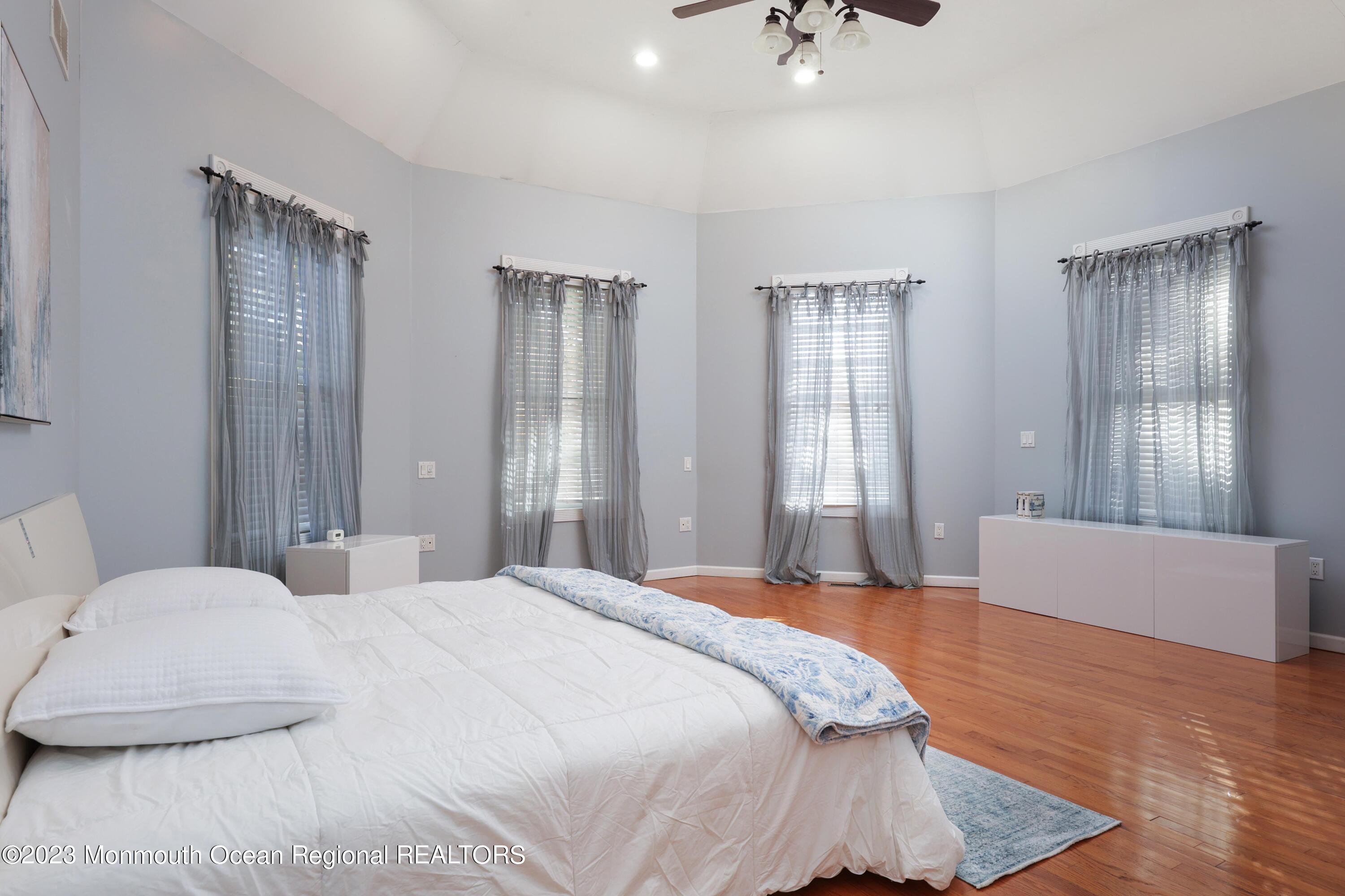 2600 Logan Road Asbury Park, NJ 07712 - Photo 17 of 36 a bedroom with a large bed and a chandelier