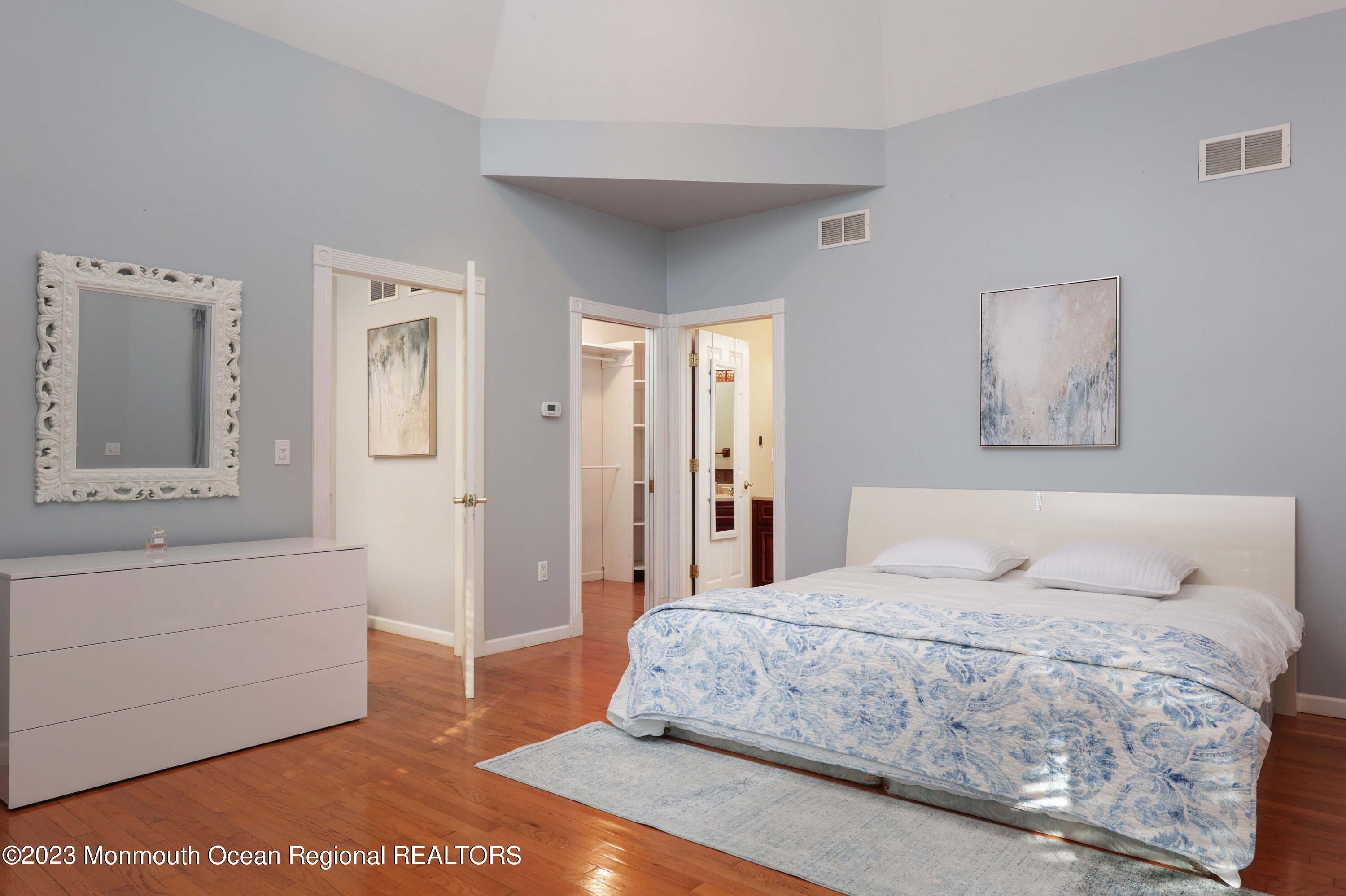 2600 Logan Road Asbury Park, NJ 07712 - Photo 18 of 36 a bedroom with a large bed and a chandelier