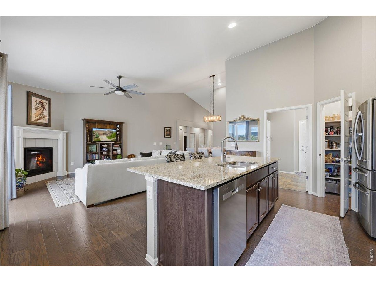 6096 Story Road Timnath, CO 80547 - Photo 15 of 50 a kitchen with a sink dishwasher a stove and a refrigerator with wooden floor