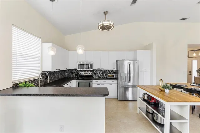 a kitchen with stainless steel appliances granite countertop a sink and a stove