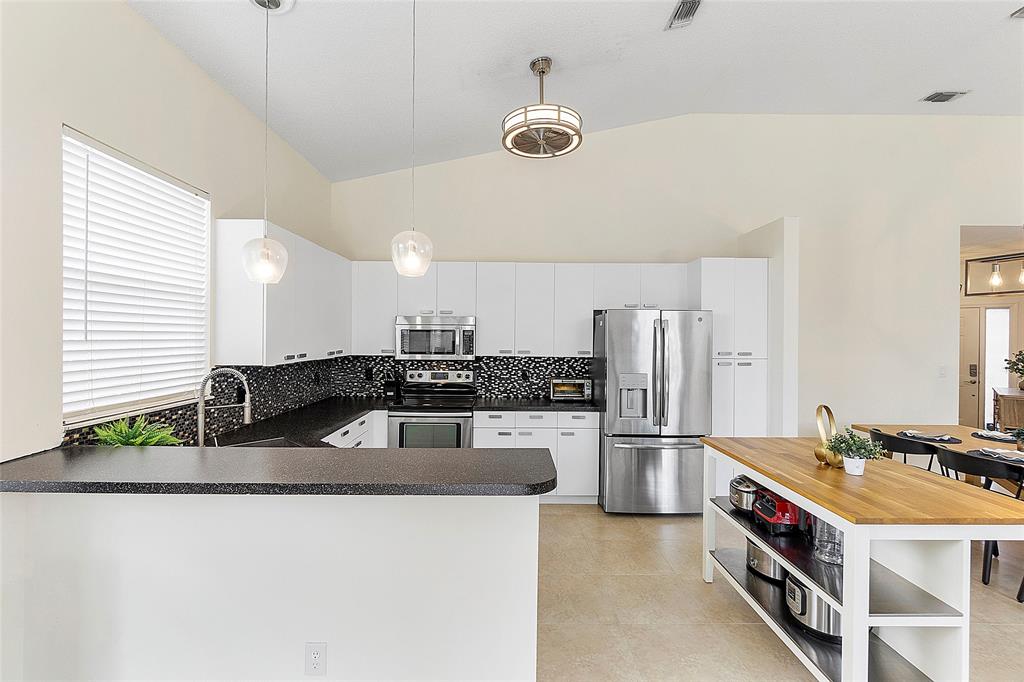10650 Northwest 48th Street Coral Springs, FL 33076 - Photo 11 of 37 a kitchen with stainless steel appliances granite countertop a sink and a stove
