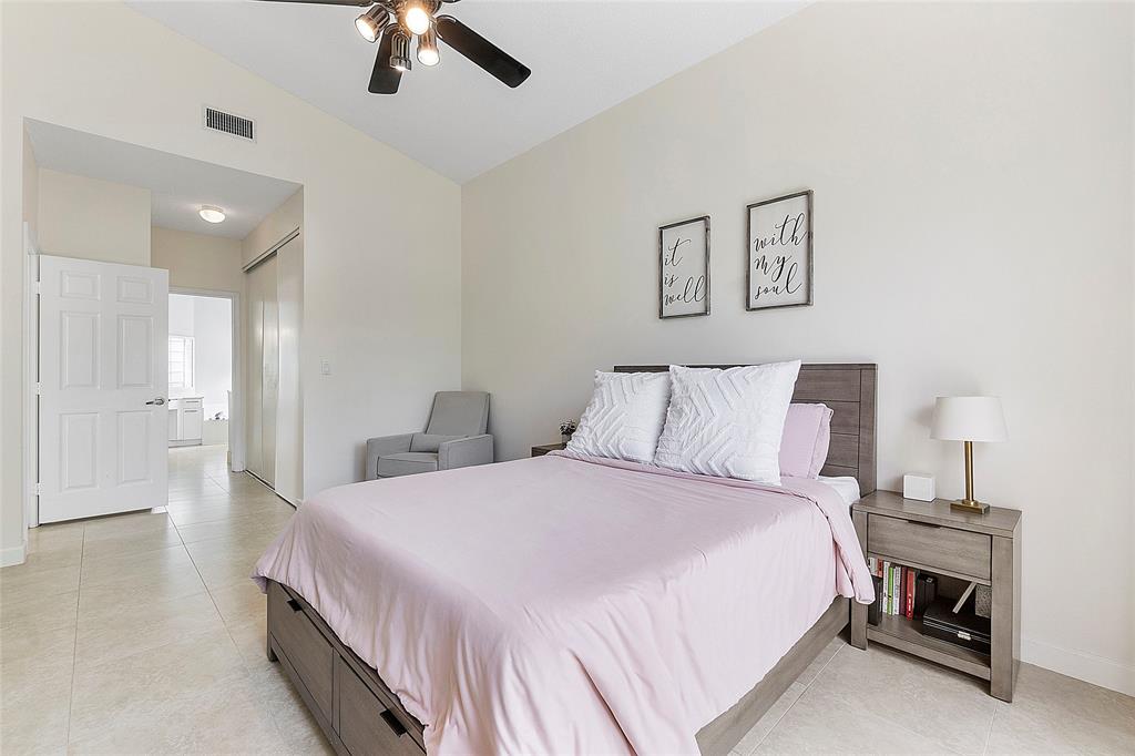 10650 Northwest 48th Street Coral Springs, FL 33076 - Photo 19 of 37 a bedroom with a bed and a chandelier