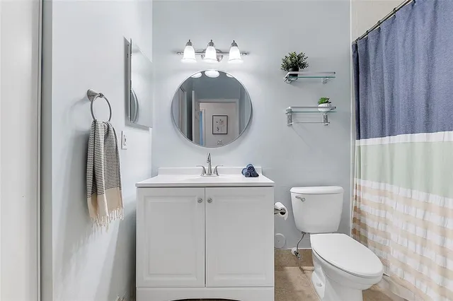 a bathroom with a toilet a sink and mirror
