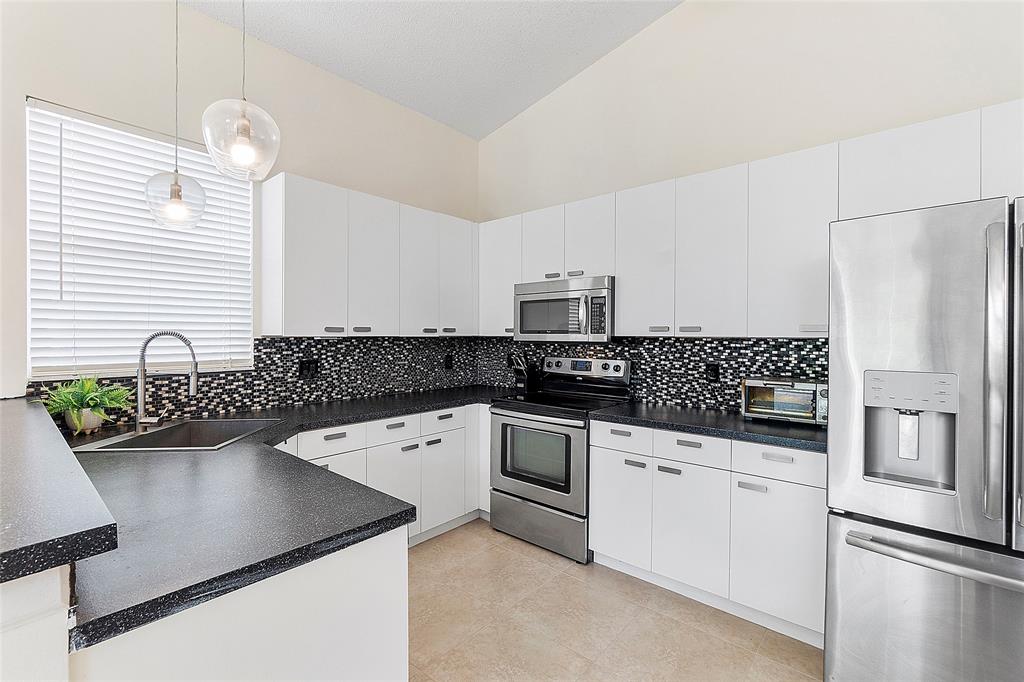 10650 Northwest 48th Street Coral Springs, FL 33076 - Photo 10 of 37 a kitchen with stainless steel appliances a sink stove and refrigerator