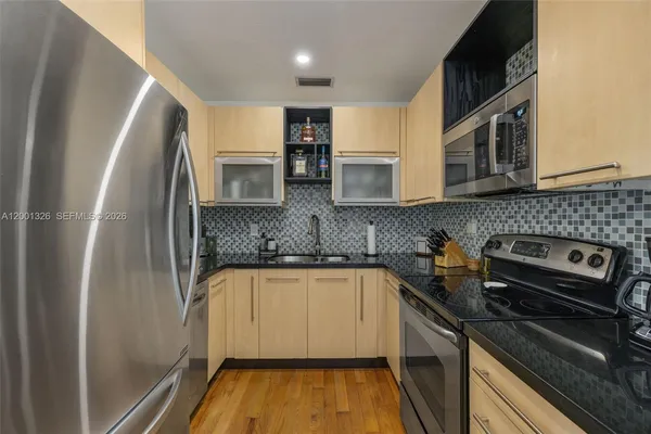a kitchen with stainless steel appliances granite countertop a sink stove and refrigerator