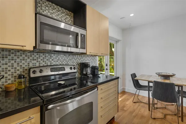 a kitchen with a stove a microwave a sink and cabinets
