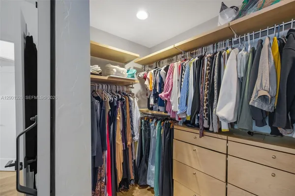 a view of walk in closet with clothes
