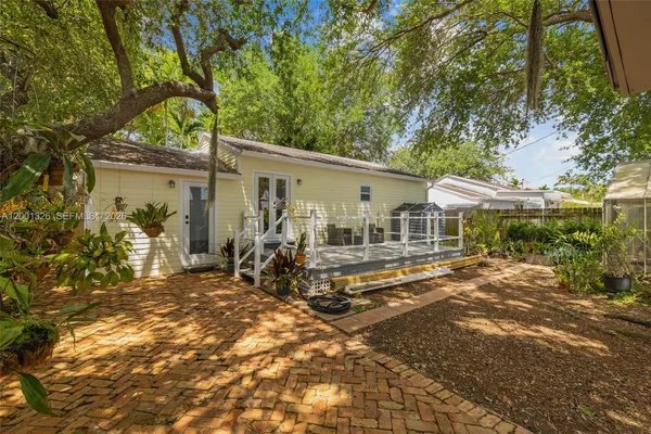 a view of a house with backyard sitting area and garden