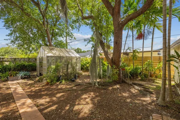 a view of a yard with plants and trees