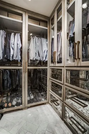 a view of walk in closet with clothes and shoes
