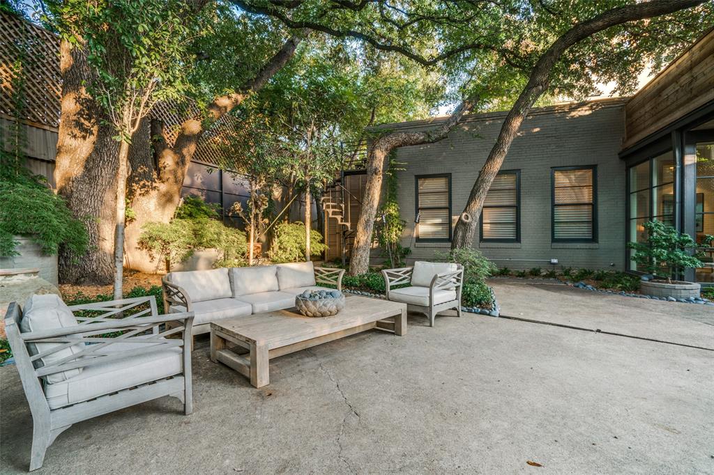 3610 Congress Avenue Dallas, TX 75219 - Photo 37 of 40 a view of a patio with couches and a table and chairs with wooden fence and large trees