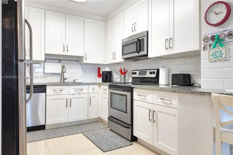 a kitchen with white cabinets stainless steel appliances and sink