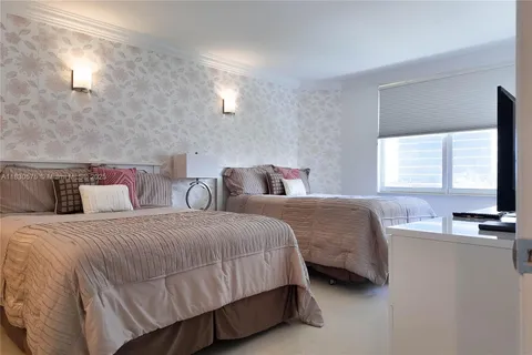 a bedroom with two beds and a flat screen tv