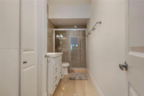 a bathroom with a granite countertop shower and a toilet