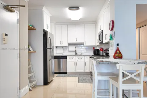 a kitchen with stainless steel appliances granite countertop a refrigerator and a stove top oven