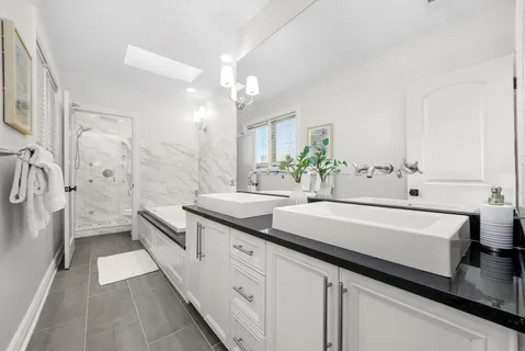 a bathroom with a granite countertop sink toilet a large mirror a bathtub and shower
