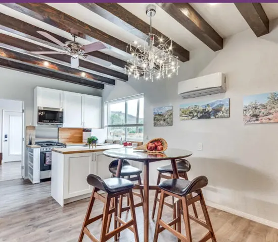 a kitchen with stainless steel appliances a table and chairs in it