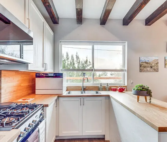 a kitchen with granite countertop a stove and white cabinets