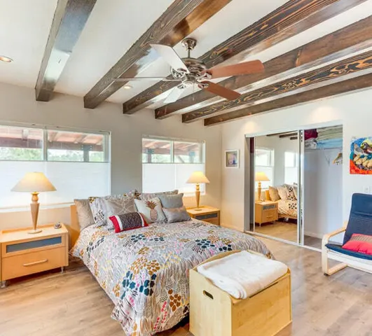 a bedroom with a bed and wooden floor