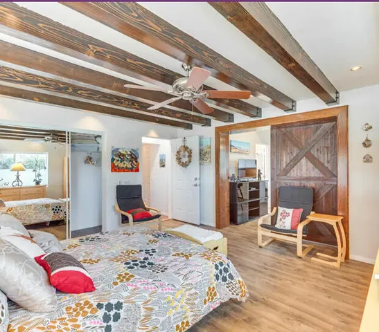 a bedroom with bed and wooden floor