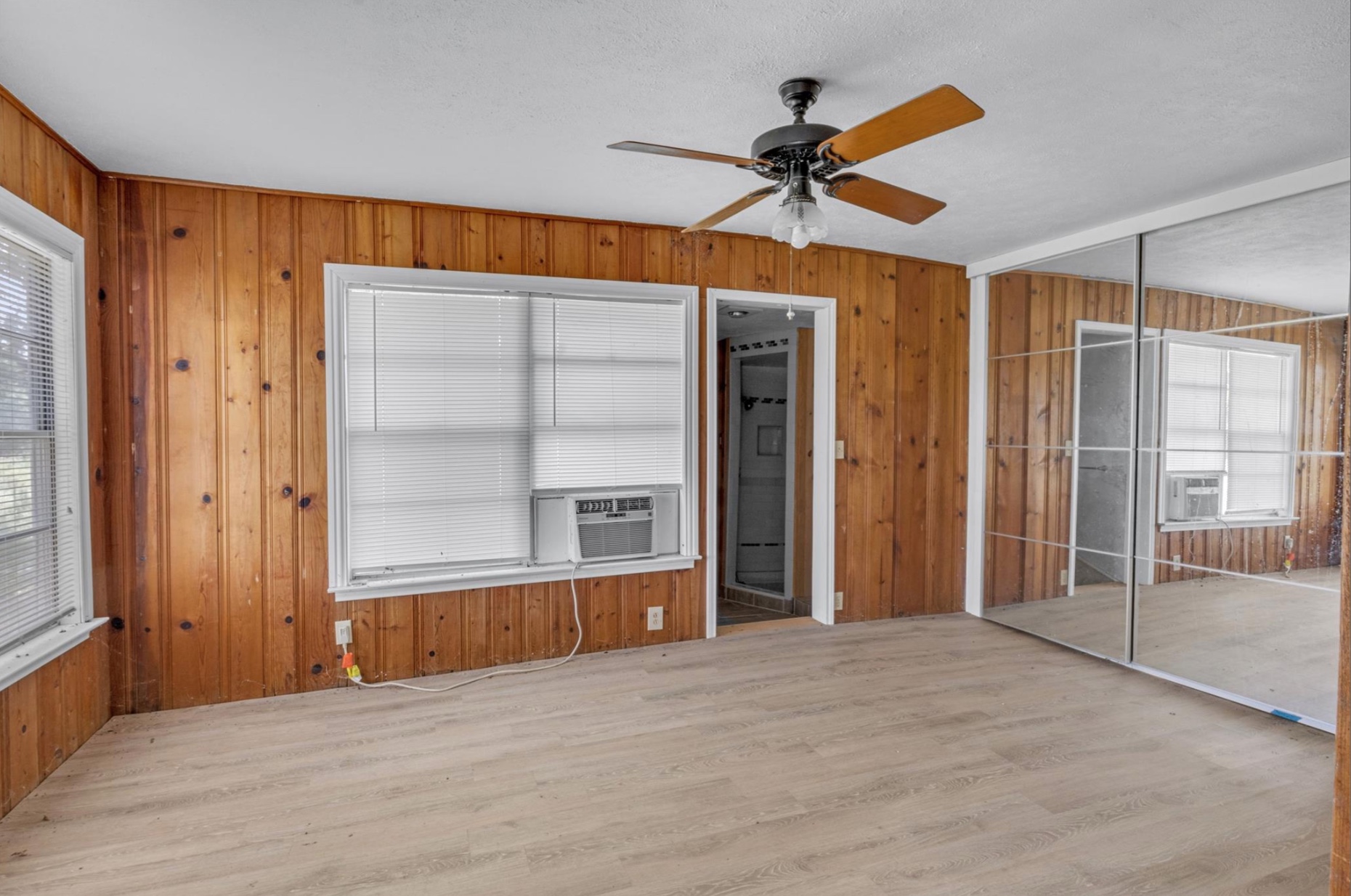 451 Pleasant Grove Road Elgin, TX 78621 - Photo 8 of 26 Unfurnished bedroom featuring multiple windows, wood finished floors, and a closet
