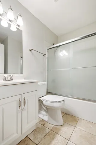 a bathroom with a sink a toilet a mirror and shower
