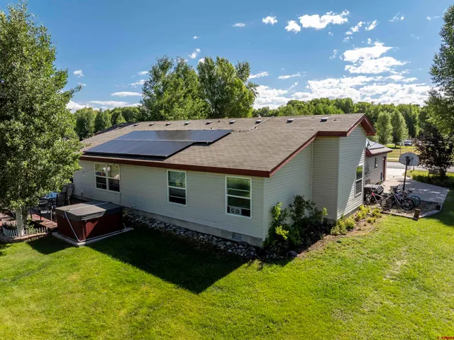 a view of a house with swimming pool lawn chairs and a yard