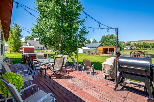 a view of a chairs and table in patio with a yard