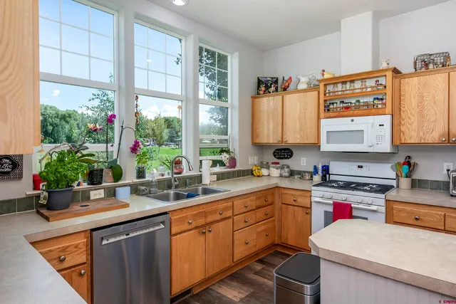 a kitchen with a sink a stove and chairs