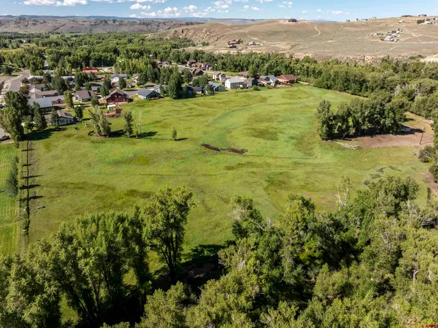 a view of swimming pool with lawn chairs and a big yard
