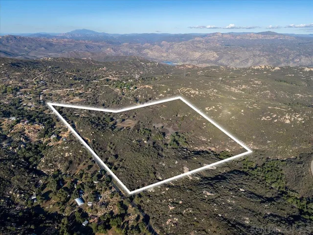 a view of a dry yard with mountains in the background