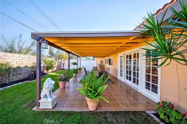 a view of a patio with table and chairs potted plants with wooden floor and fence