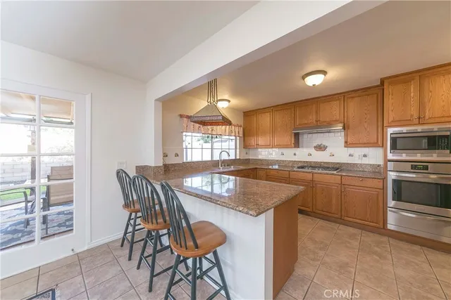 a kitchen with kitchen island granite countertop wooden floors and white appliances