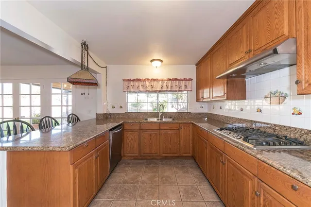 a kitchen with stainless steel appliances granite countertop a sink stove and cabinets
