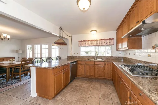 a kitchen with stainless steel appliances granite countertop a stove top oven a sink dishwasher and cabinets