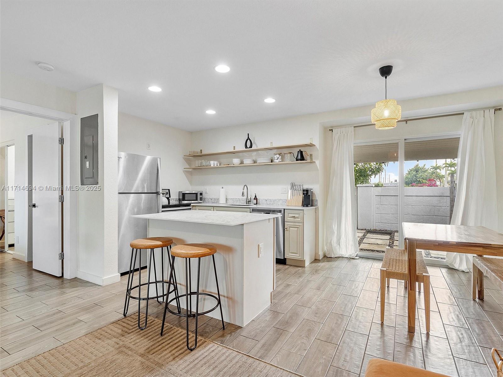 300 Southwest 23rd Street Fort Lauderdale, FL 33315 - Photo 16 of 43 a kitchen with a dining table chairs appliances and cabinets