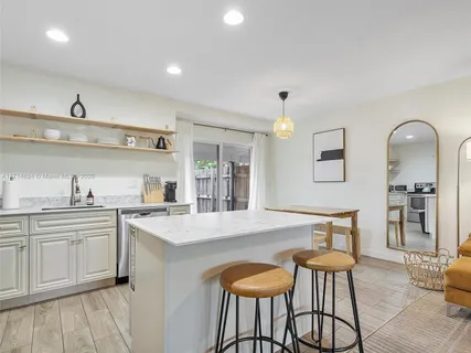 a large kitchen with cabinets a sink and appliances
