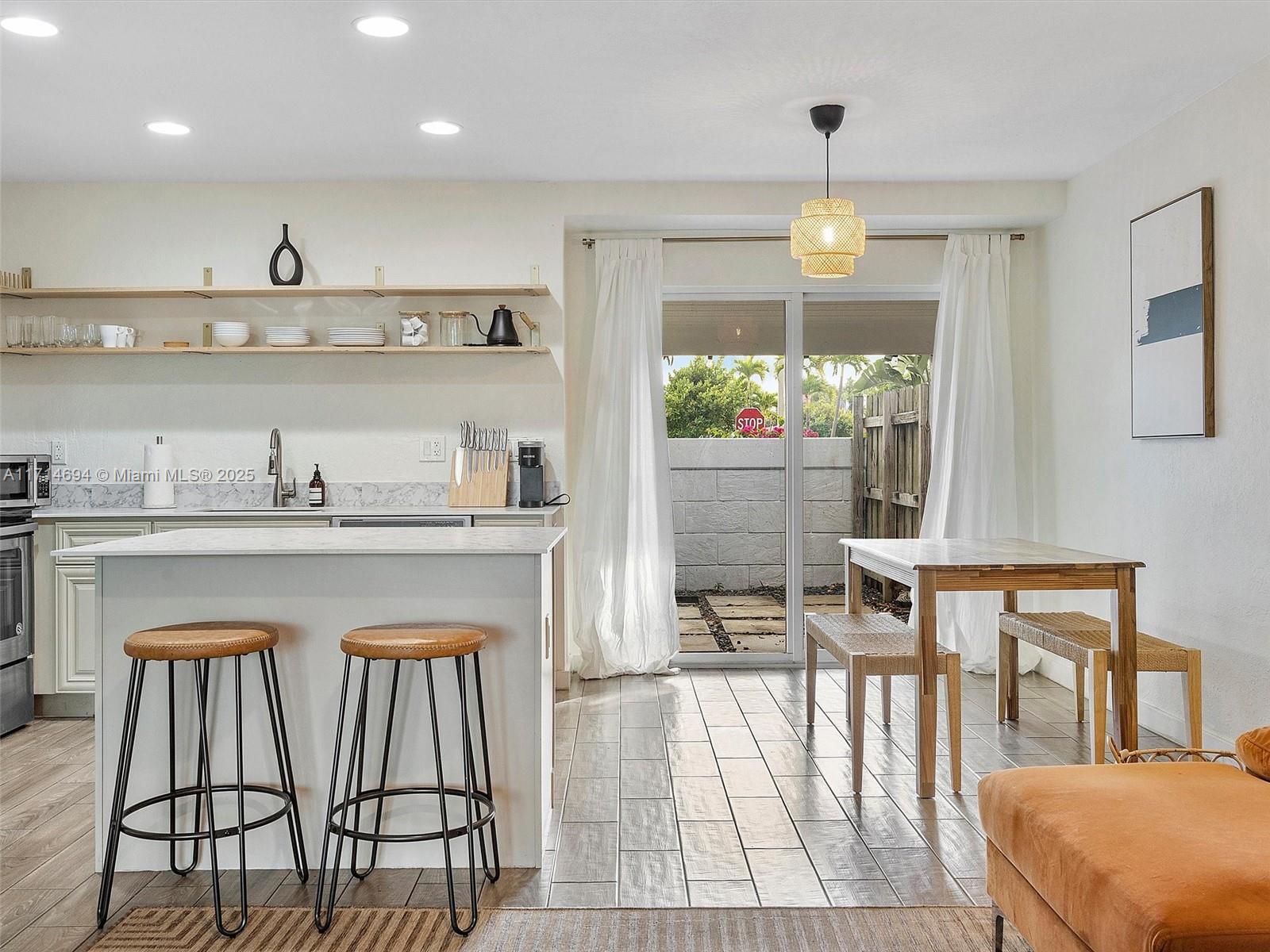 300 Southwest 23rd Street Fort Lauderdale, FL 33315 - Photo 18 of 43 a kitchen with stainless steel appliances granite countertop a table chairs in it and wooden floors