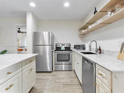 a kitchen with white cabinets and stainless steel appliances