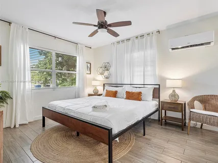 a bedroom with a large bed and a potted plant